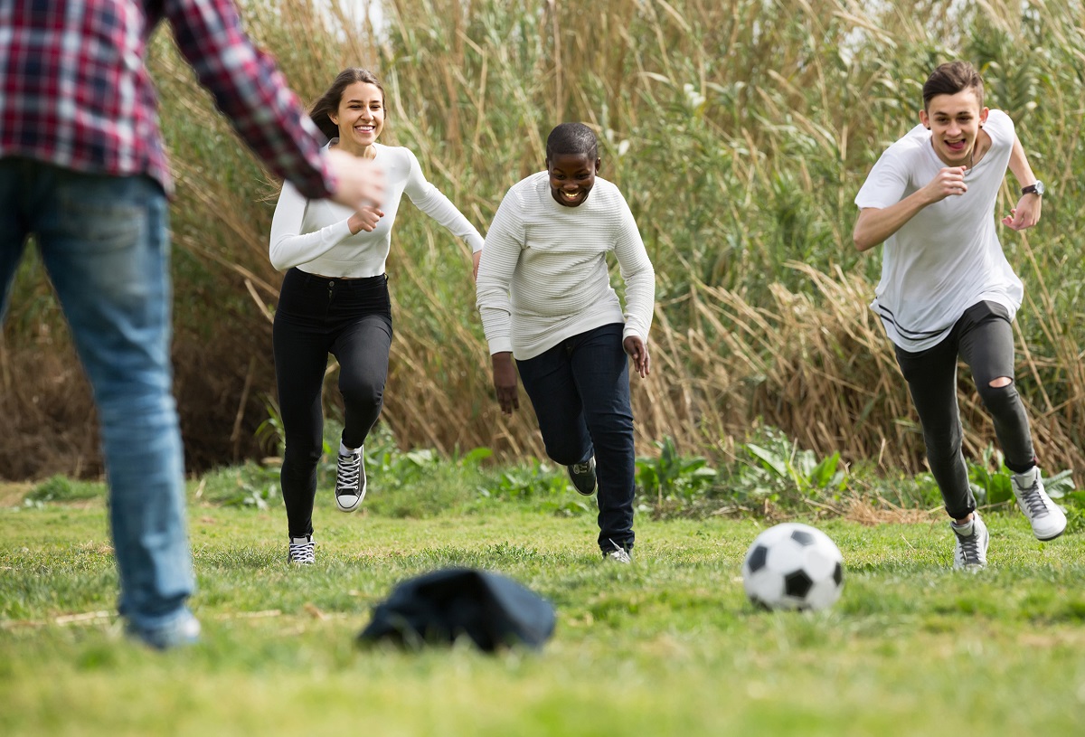 Kids play with a soccer ball in a field 