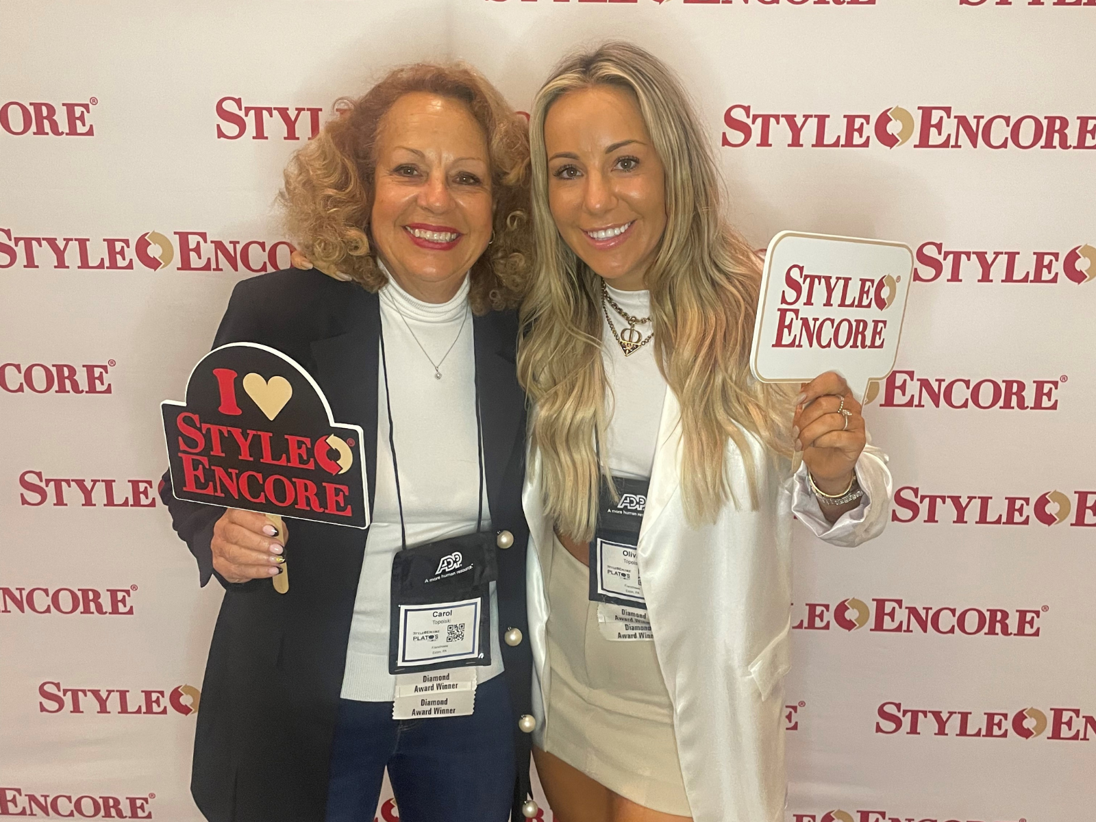 two women posing with Style Encore signs